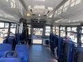 Interior view of a 2020 Chevrolet Express with blue seating and large windows showcasing a spacious layout designed for passengers