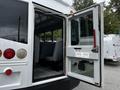 A 2015 Spartan School Bus with an open door revealing gray seats inside