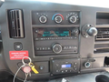 Dashboard controls and radio system of a 2020 Chevrolet Express including knobs buttons and a key in the ignition