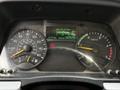 Dashboard of a 2015 Mitsubishi Fuso FE displaying speedometer and tachometer dials along with a digital screen showing average fuel consumption and odometer reading