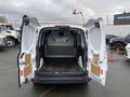 A 2017 Ford Transit Connect with its rear doors open revealing a spacious cargo area equipped with a protective barrier and a flat floor