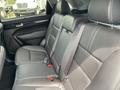 A black leather interior of a 2015 Kia Sorento showing the back seat with headrests and seat belts