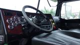 Interior view of a 2019 Western Star Trucks 4900 SA featuring a black leather seat a detailed dashboard and a steering wheel with various controls and gauges