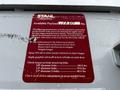 2013 Ford F-650 with a maintenance sticker detailing available payload and maintenance instructions for tailgate mechanisms and mounting bolts