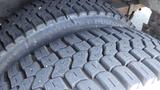 Two truck tires stacked on top of each other showcasing their tread patterns and rubber surfaces