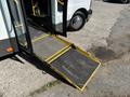 A 2017 Chevrolet Express with a deployed yellow wheelchair ramp at the entrance door