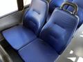 Two blue upholstered seats in a 2019 Chevrolet Express interior with a textured pattern and sturdy armrests