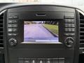 A screen display in a 2020 Mercedes-Benz Metris showing a rearview camera view of the surroundings with a message to check the entire area