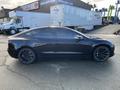 A black 2019 Tesla Model 3 parked with a sleek design and sporty rims