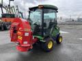 A 2014 John Deere 1585 Terrain Cut with a red grass cutting attachment on the rear and a green cab enclosure