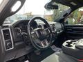 A 2021 RAM 1500 interior featuring a steering wheel dashboard and center console with cup holders and controls