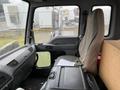 Interior view of a 2006 GMC F7B042 truck cab showing the driver's seat dashboard and a storage container on the floor