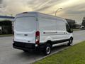 2017 Ford Transit van with a white exterior and rear cargo doors parked on a street