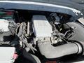 Engine compartment of a 1962 Ford F-100 showcasing a modern engine with a silver cover and various components including a battery and hoses