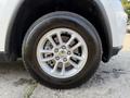 A close-up view of a 2020 Jeep Grand Cherokee wheel featuring a silver alloy rim and a black tire with visible tread details