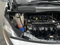 A 2014 Ford Transit Connect engine compartment showing the engine, coolant reservoir, and various components and hoses