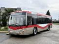 A 2016 Grande West Vicinity bus with a red and silver exterior parked with the front view visible