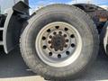 A close-up of a large wheel from a 2022 Freightliner Cascadia featuring a multi-stud pattern and heavy-duty tire tread designed for durability and traction