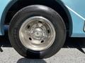 Close-up of a chrome wheel rim and tire on a blue 2000 Ford Motorhome