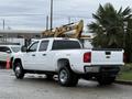 A white 2013 Chevrolet Silverado 3500HD parked with a crew cab and four-wheel drive badge visible on the side