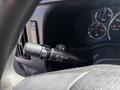 Close-up of the turn signal lever and dashboard instruments in a 2017 Chevrolet Express showing speedometer and various gauges