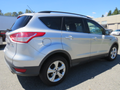 A 2015 Ford Escape in silver with a compact SUV design featuring a rear hatch and alloy wheels