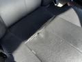 Close-up of a worn leather seat in a 2022 Freightliner Cascadia showing a tear in the material and exposed padding beneath