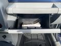 A 2007 Chrysler PT Cruiser with an open glove compartment containing a folded manual and dark floor mats visible
