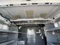 Interior of a 2016 Ford Transit van showing metal shelving units along the sides with a fire extinguisher mounted on the rear divider