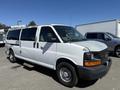 A white 2007 Chevrolet Express van with a gray front bumper and visible wear on the paint, parked with its side facing the viewer and a step visible beneath the side door