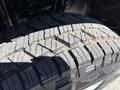 Close-up view of a tire showing a detailed tread pattern on a 2014 Ford F-250 SD with visible wear and grooves designed for traction on various terrains