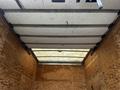 Interior view of a 2012 Mitsubishi Fuso FE truck showing a partially open cargo area with wooden walls and a ceiling designed for storage