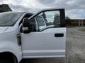 White 2020 Ford F-250 SD with a partially open driver's side door and side mirror visible