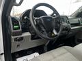 Interior view of a 2017 Ford F-150 featuring a steering wheel dashboard with gauges and controls along with a gear shift and seats in a gray fabric