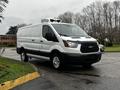 A 2016 Ford Transit van in white with a black grille and chrome wheels facing slightly to the left