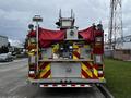 Rear view of a 2009 Spartan Gladiator fire truck featuring red and yellow striped markings multiple lights and a covered ladder compartment