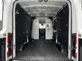 Interior view of a 2021 Ford Transit van showing a spacious cargo area with black walls and a partitioning wall at the rear