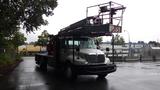 A 2010 International 4300 bucket truck with a working platform extended from the truck bed