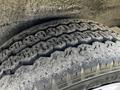 Close-up of a worn tire from a 2017 Nissan NV200 showcasing its tread pattern and dirt accumulation on the surface