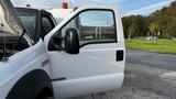 A white 2007 Ford F-550 with its driver's side door open showcasing the interior and dashboard