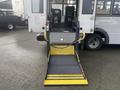 A 2018 Chevrolet Express with a deployable yellow wheelchair lift in the rear entry area