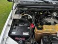 Close-up of the engine bay of a 2004 Ford F-450 SD showing the battery coolant reservoir and various engine components