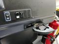 Interior view of a 2022 Blue Bird BB Conventional showing control buttons and a cup holder assembly