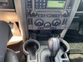 Interior view of a 2006 Land Rover LR3 dashboard showing the control panel and gear shift with cup holders below