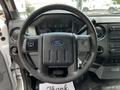 Steering wheel of a 2016 Ford F-550 with controls and dashboard indicators visible in the background