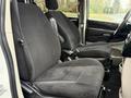 Two front seats of a 2011 Dodge Grand Caravan upholstered in black fabric with adjustable headrests and armrests