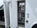 A 2016 Chevrolet Express with an open side door displaying complex wiring and electronic components inside the vehicle's compartment