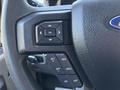 Steering wheel of a 2015 Ford F-150 with control buttons including OK set and cancel options