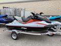 A jet ski with a sleek design featuring a black and red color scheme mounted on a silver trailer