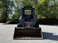 A 2017 Gehl R105 skid steer loader facing forward with a large bucket attachment in front and a black seat visible inside the cab